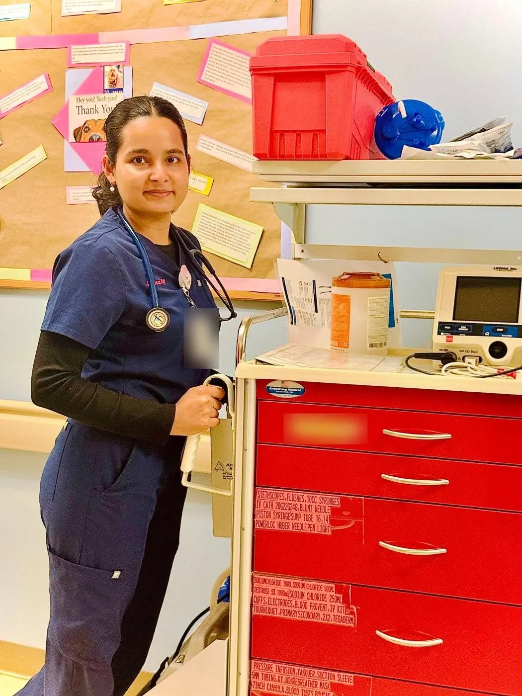 Sabina Uprety, RN, beside a medication cart
